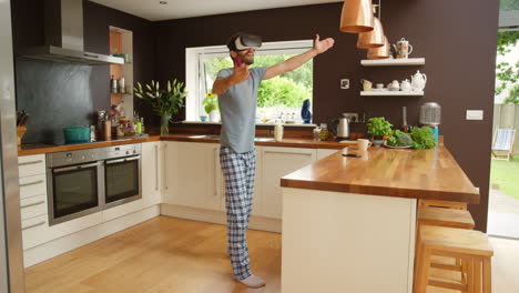 Excited-young-man-dancing-in-his-kitchen-wearing