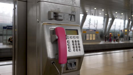 Handaufnahme-Eines-Rosafarbenen-Münztelefons-Am-Frankfurter-Flughafen