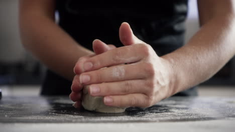 an-unrecognizable-woman-kneading-dough-at-home