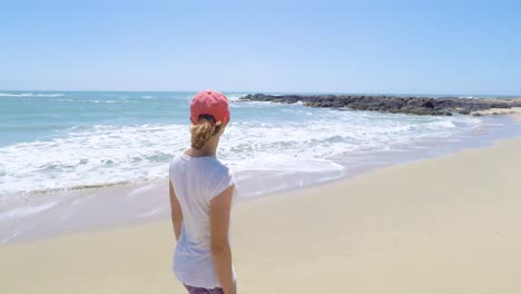 Young-woman-walking-on-a-beach-on-West-Coast,-USA
