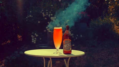 A-freshly-poured-beer-glass-of-Zwickel-kellerbier-from-Urban-Chestnut-brewery-sits-in-front-of-a-smoky-barbecue-fire