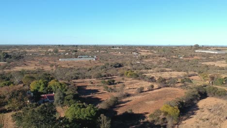 A-push-in-drone-shot-of-a-countryside-area-in-Bulawayo,-Zimbabwe-under-sunny-conditions