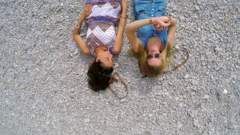 Two-friends-lying-on-a-gravel-dirt-road-together