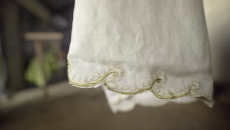 Decorative-white-cloth-drying-on-clothing-line-in-warm-windy-weather,-closeup