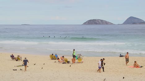 People-hanging-out-at-Ipanema-beach,-Guanabara-bay,-Rio-de-Janeiro,-Brazil