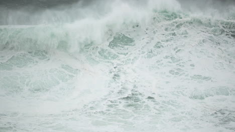 Big-Foamy-Waves-Crashing-By-The-Sea-In-Nazare,-Portugal-In-Slow-Motion---Closeup-Shot