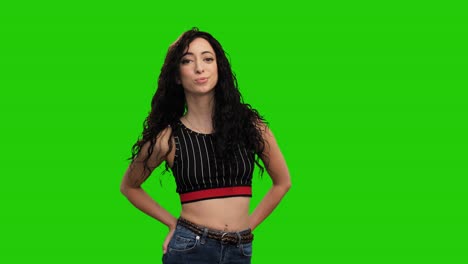 Beautiful-fit-female-holds-hands-in-pockets-and-turns-on-green-screen