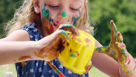 a-little-girl-playing-with-paint-outdoors