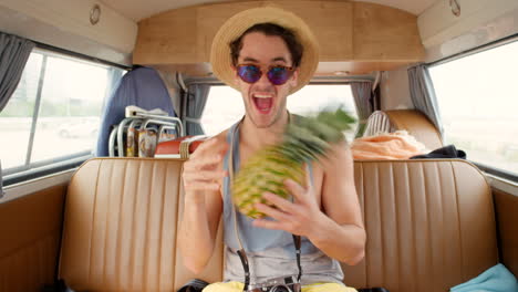 A-young-man-having-fun-playing-with-a-pineapple