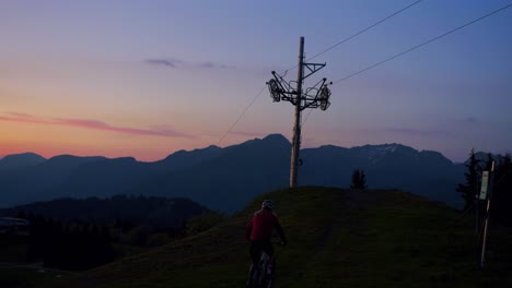 Mountainbiker-Radelt-Im-Dunkeln-Einen-Hügel-Hinauf,-Während-Die-Sonne-Untergeht