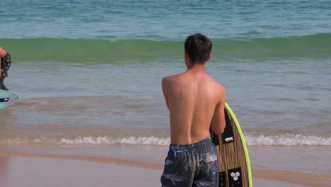 A-man-is-seen-with-his-surfboard-at-Shek-O-beach-in-Hong-Kong-as-public-beaches-reopening,-after-months-of-closure-amid-coronavirus-outbreak,-to-the-public