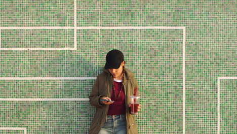 A-woman-relaxing-against-a-tile-wall-using