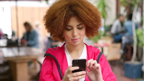 Mujer-Joven-Nerviosa-Con-Afro-Rojo-Usando-Su-Teléfono