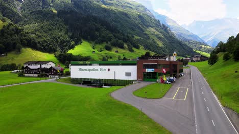 Aerial-cinematic-rising-shot-of-Elmer-mineral-water-plant-in-Elm,-Glarus,-Switzerland