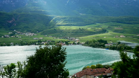 Bunt-Reflektierter-Kalterer-See-In-Italien-Mit-Wunderschöner-Ländlicher-Landschaft-Im-Hintergrund-An-Sonnigen-Tagen-In-Italien