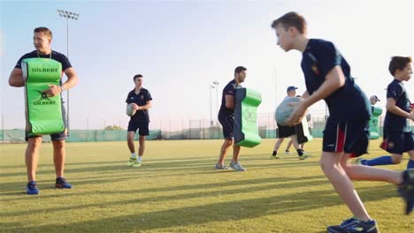 Junge-Rugbyspieler-Auf-Dem-Spielfeld-Während-Des-Trainingstrainings-Mit-Ihren-Trainern-–-Nahaufnahme-Aus-Der-Tiefwinkelaufnahme