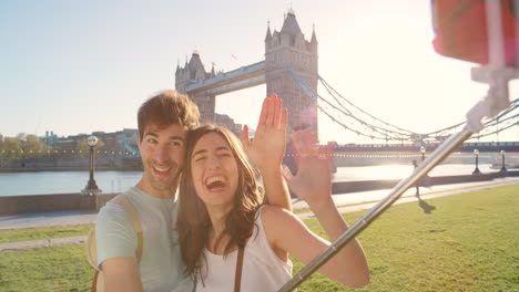 A-cheerful-young-couple-waving-during-a-selfie