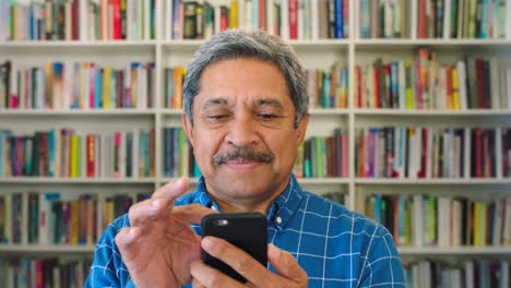 Older-male-bookstore-owner-using-a-phone-inside