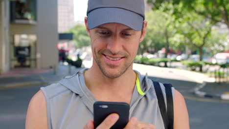 Sportler-Benutzt-Sein-Telefon-Draußen-In-Einer-Stadt