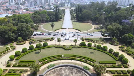 Revealing-the-city-of-Sao-Paulo,-Brazil-and-the-Independence-Monument-in-the-background-from-the-gardens-of-the-Ipiranga-Museum