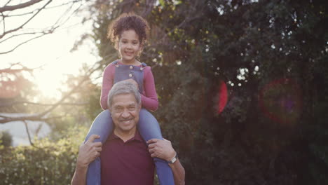 Cheerful-senior-man-carrying-his-granddaughter