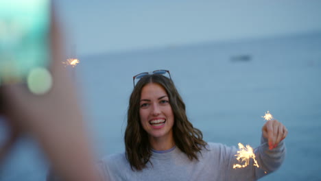 A-happy-woman-playing-with-a-sparkler-on-the-beach
