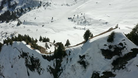 High-angle-jib-down-of-trees-on-top-of-mountain-overlooking-snow-covered-valley