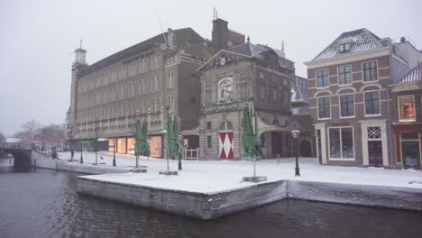 Leiden-Waag-restaurant-on-Rhine-riverside-in-winter-snow,-Netherlands