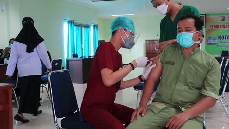 Sehr-Lärm--Und-Filmkornclip,-Arzt-Hält-Spritze-Und-Verwendet-Baumwolle,-Bevor-Er-Dem-Patienten-In-Medizinischer-Maske-Covid-19-Oder-Coronavirus-impfstoff-Injiziert,-Pekalongan,-Indonesien,-11.-Februar-2021