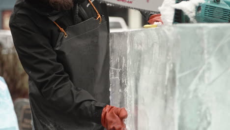 Ice-sculptor-inspecting-and-rubbing-ice-block,-Slow-Motion