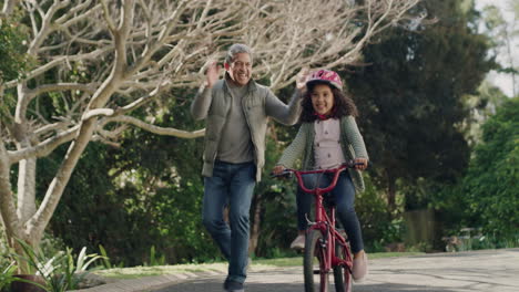 Grandfather-teaching-child-to-cycle-on-her-first