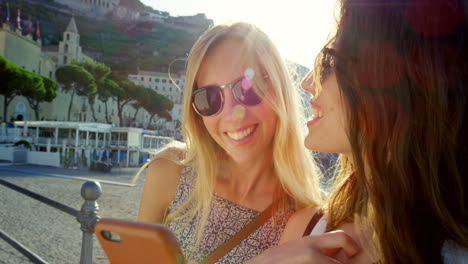 Two-women-using-a-smartphone-while-on-vacation