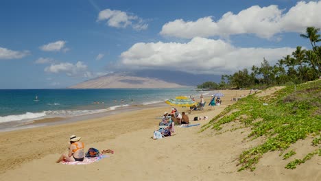 People-sitting-on-a-beach-in-Maui,-Hawaii
