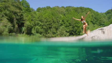 A-young-woman-having-fun-jumping-into-a-lake