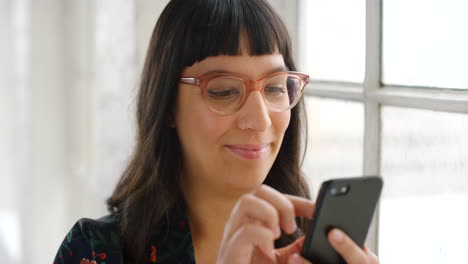 Trendige-Frau-Mit-Brille,-Die-Ihr-Telefon-Benutzt