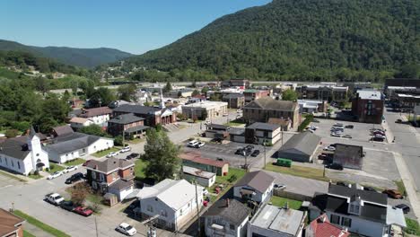 aerial-push-into-pineville-kentucky-with-church-in-foreground,-small-town-america,-hometown,-small-town-usa,-middle-america-in-the-suburbs