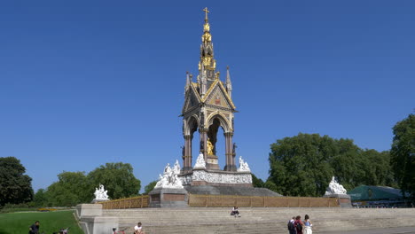People-At-The-Albert-Memorial-In-Kensington-Gardens,-London,-UK-With-Clear-Blue-Sky-Background