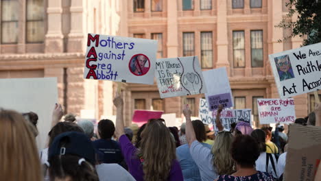 People-wave-signs-in-protest-of-Texas-Governor-Greg-Abbott-and-Texas-Senate-Bill-8-during-Women's-March-Rally-at-Texas-Capitol-in-downtown-Austin