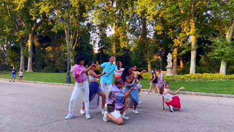 Group-of-international-people-and-LGTB-collective-dancing-the-end-of-a-choreography-in-the-Retiro-Park-in-Madrid,-Spain