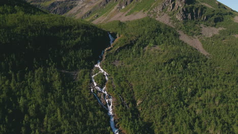 River-with-waterfalls-in-alpine-landscape-of-Northern-Norway,-aerial-dolly-out