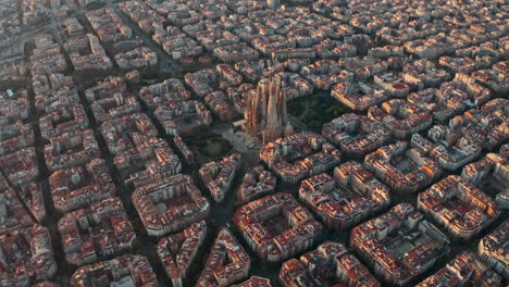 Hohe-Kreisende-Drohnenaufnahme-Der-Kirche-La-Sagrada-Familia-In-Barcelona-Bei-Sonnenaufgang