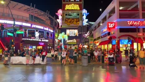 Fremont-Street-Experience-in-Downtown-Las-Vegas-with-Many-different-lights-and-colors-with-tourists-walking-across-the-street-and-traveling-during-COVID-19-pandemic-wearing-masks