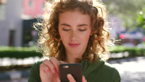 Mujer-Joven-Feliz-Enviando-Mensajes-De-Texto-En-Un-Teléfono-En-La-Ciudad