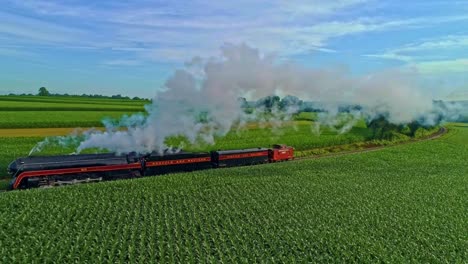 Aerial-Landscape-of-Farmlands-and-a-Antique-Steam-Engine-Passes-Thru-the-Corn-Fields-and-Running-Parallel-on-an-Early-Summer-Morning
