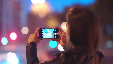 Video-De-Ciudad-De-Noche,-Mujer-Con-Smartphone