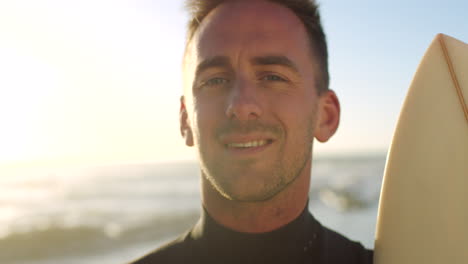 Portrait-of-fit-surfer-holding-surfboard
