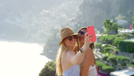 Two-women-posing-to-take-selfies-on-a-cellphone