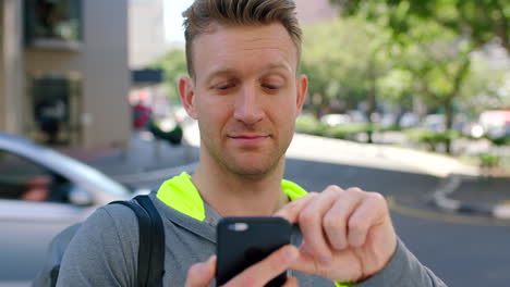 Young-fit-man-using-a-phone-outside-in-the-city