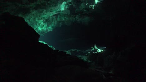 Scuba-Divers-in-Cave-system-Cenote-Tajma-Ha-in-Yucatan-Mexico-and-reflection-on-water-surfacce