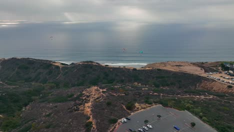 paragliders-flying-from-launch-pad-above-hill-on-the-coast-of-La-Jolla,-San-Diego,-CA